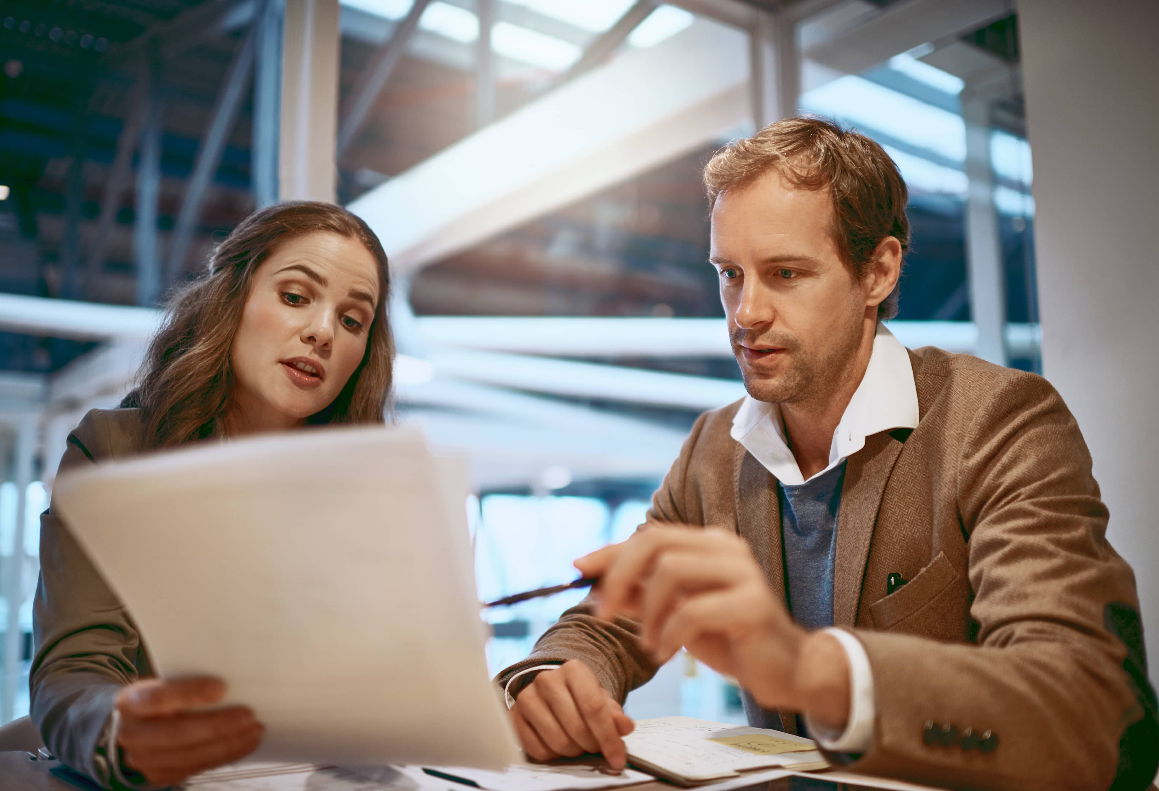 Discussion, meeting and business people with documents in office for company policy, contract and b2b deal. Partnership, corporate and man and woman with paperwork for agreement, consulting or report