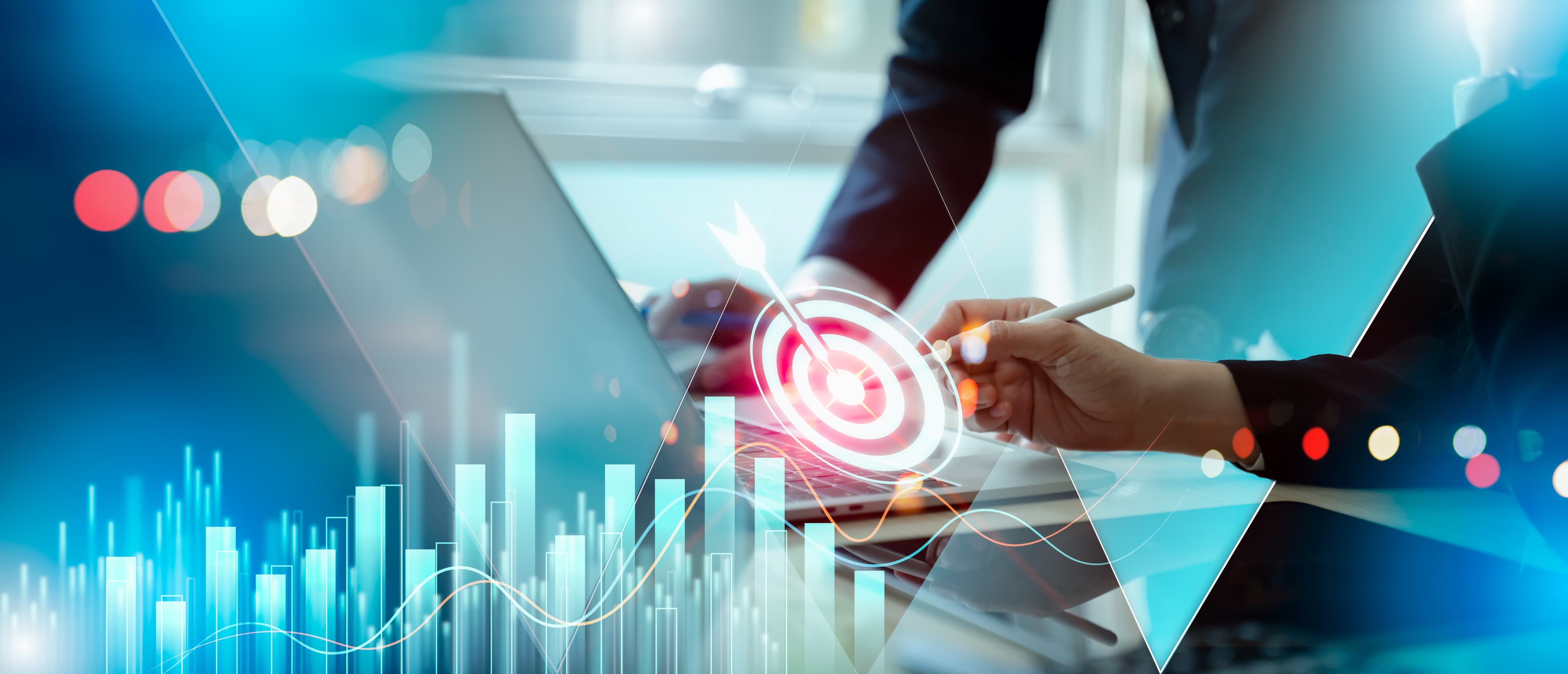 Businessperson working on laptop with digital overlay of target bullseye, bar charts, and growth graphs representing business goals.