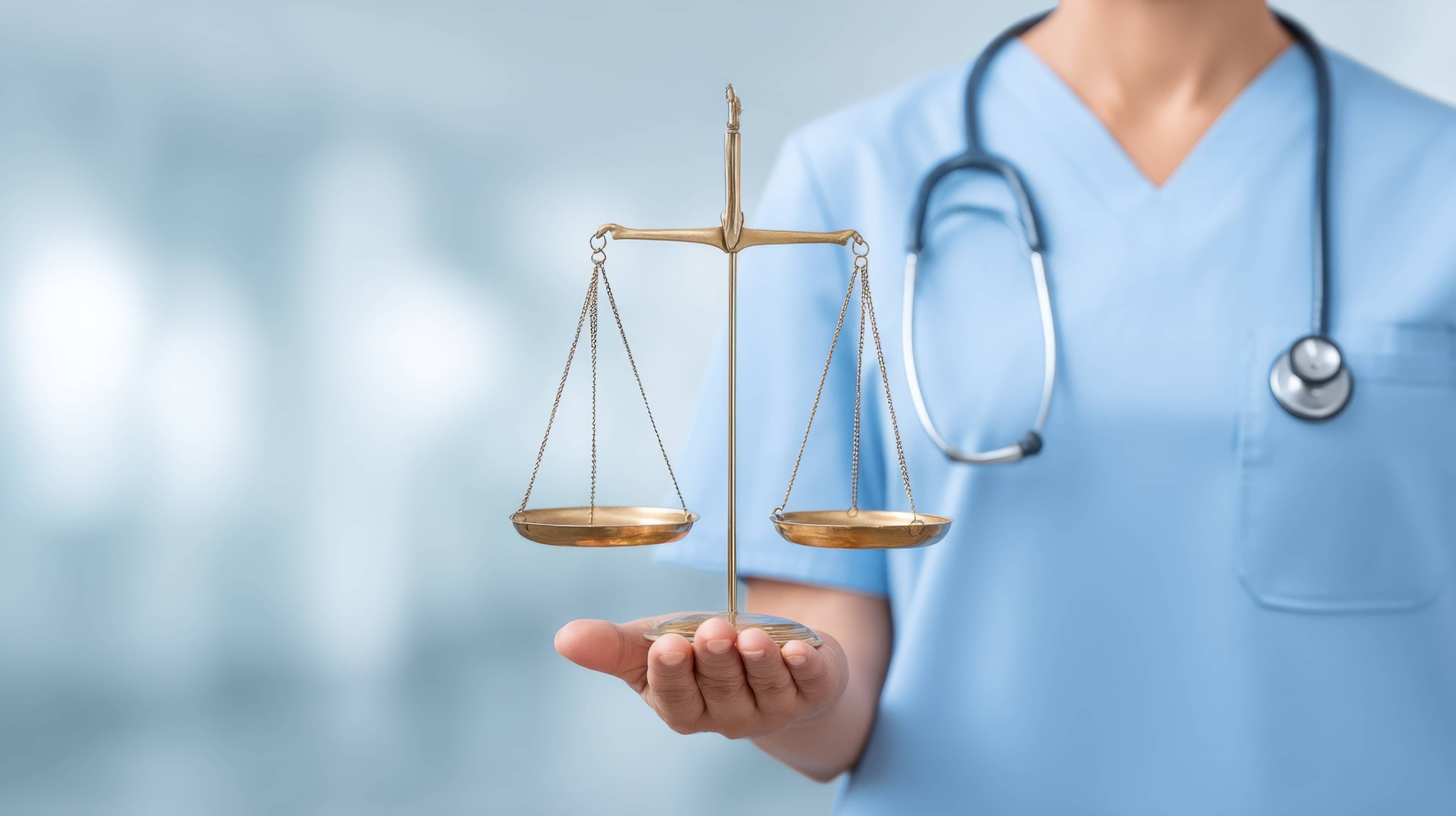 A person in medical scrubs holds a balancing scale, symbolizing the intersection of healthcare and justice, with a blurred background.