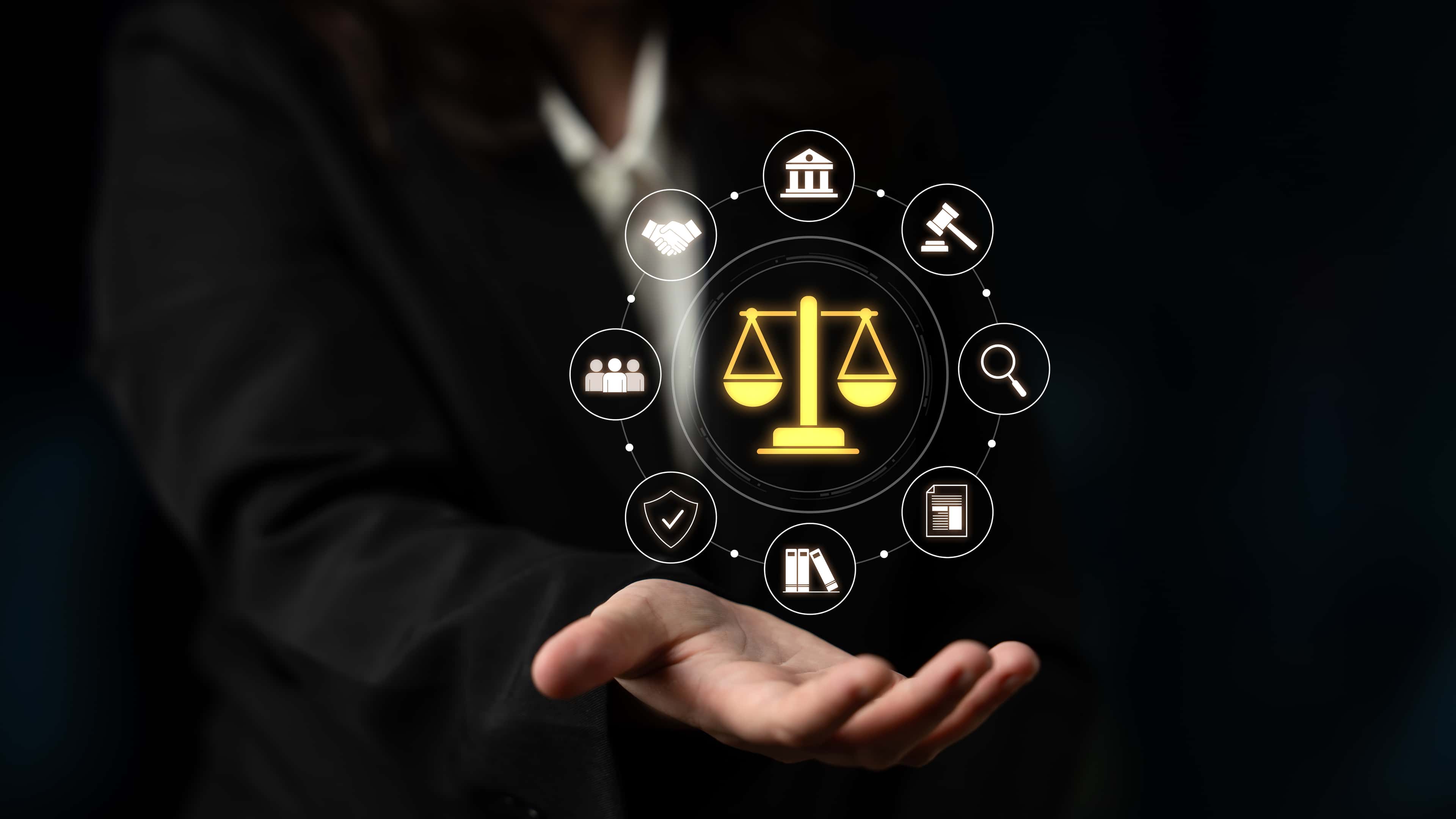 Hand holding digital law symbols, including scales of justice, gavel, documents, and handshake, representing legal concepts and justice.
