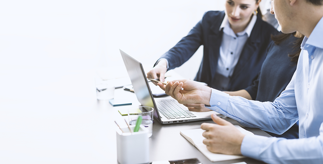 Image of people pointing to a laptop