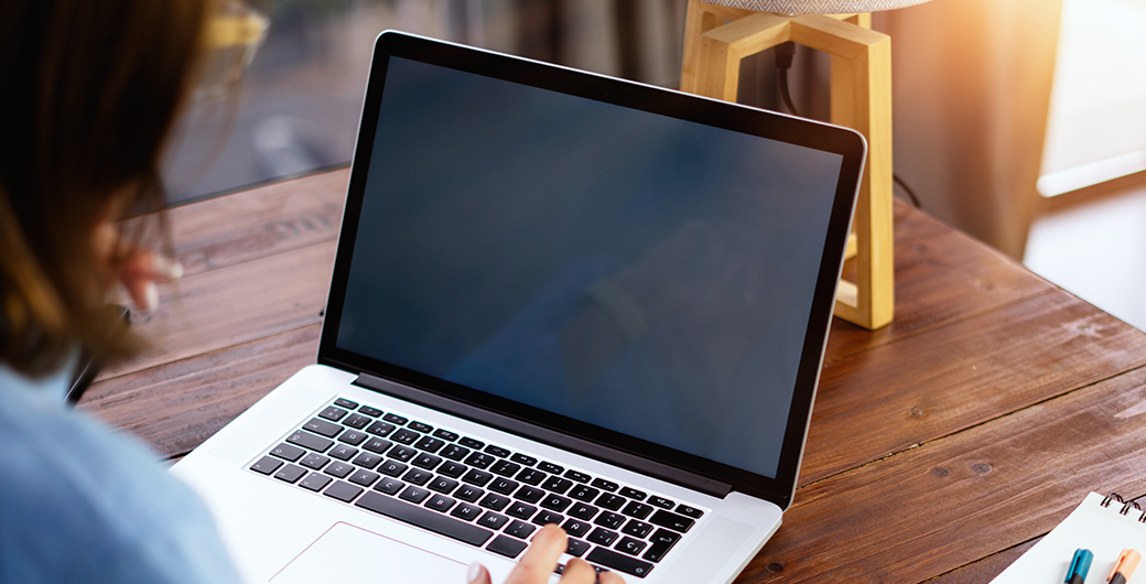 Image of a woman using laptop on wooden table