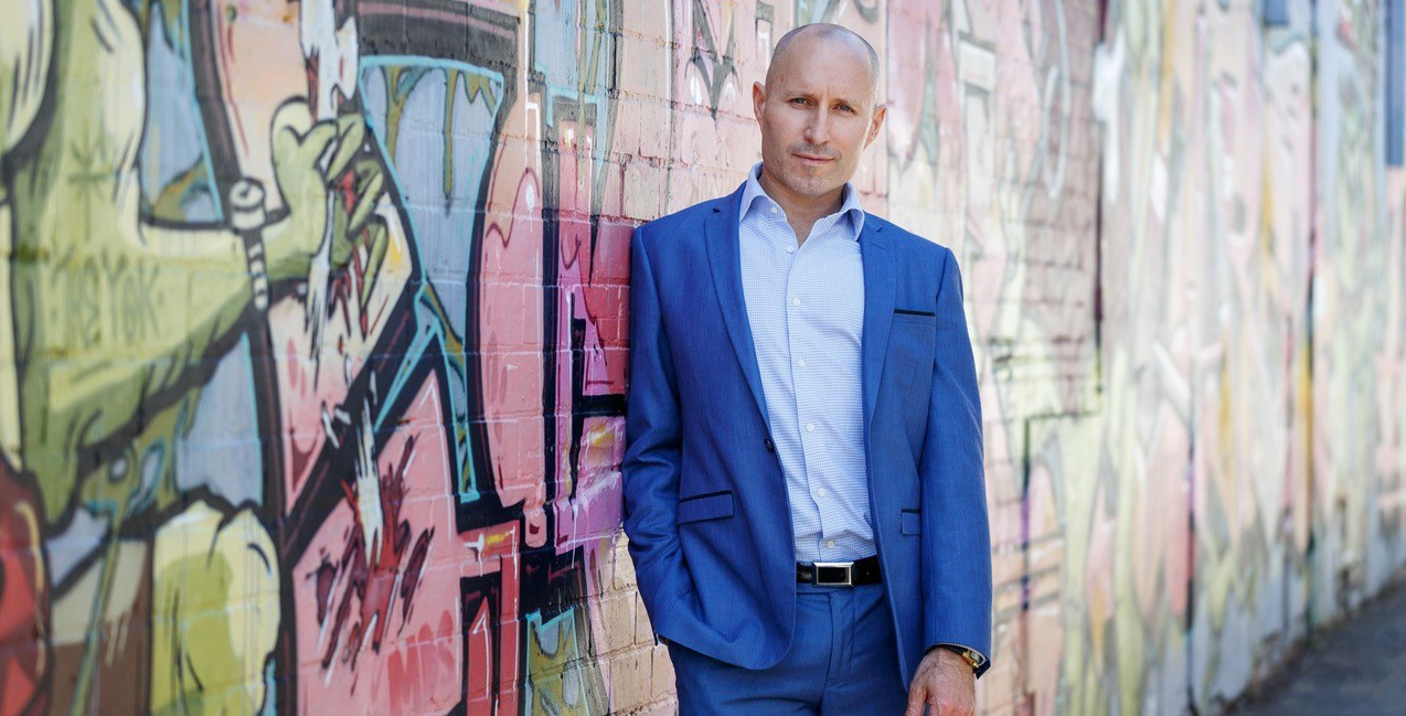 Image of David MacLennan facing the camera and leaning against the wall.