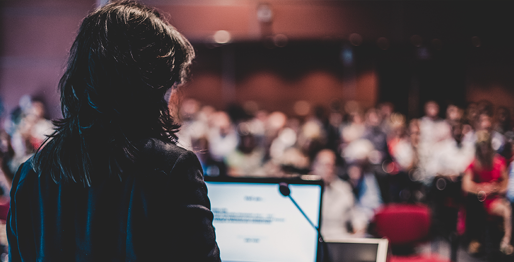 Image of a public speaker giving a talk at Business Event