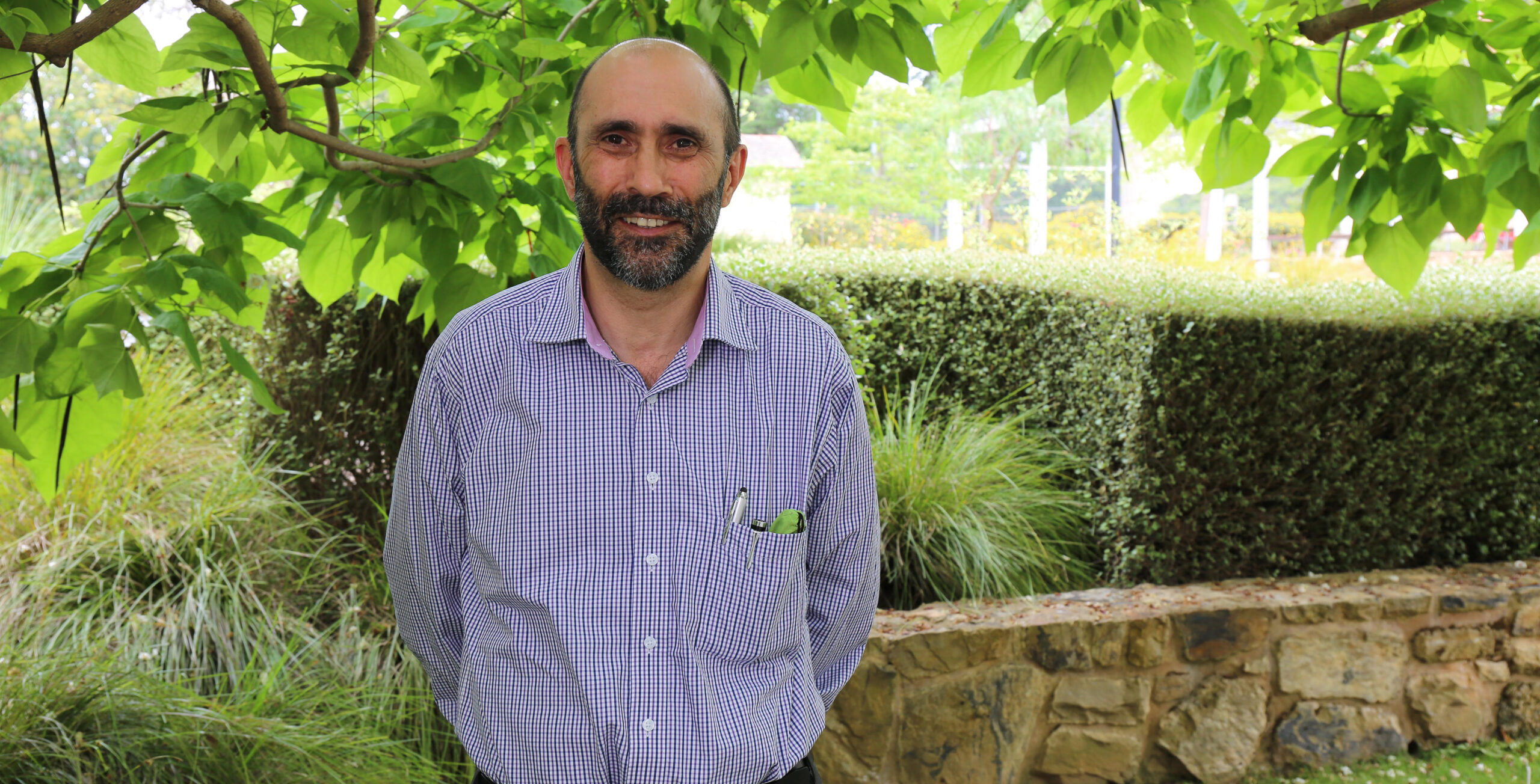 image of Ian Hamm standing and smiling at the camera.