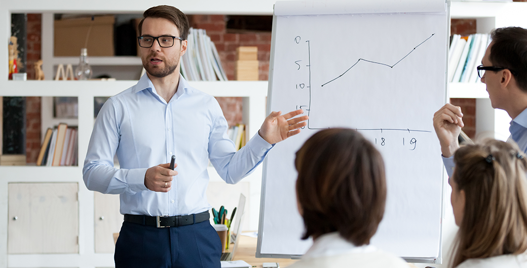 Image of a man giving a presentation with graph showing growth