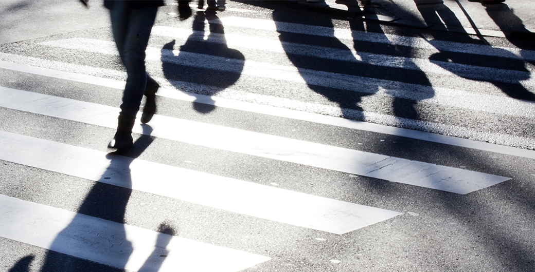 Image of blurry zebra crossing with pedestrians making long shadows