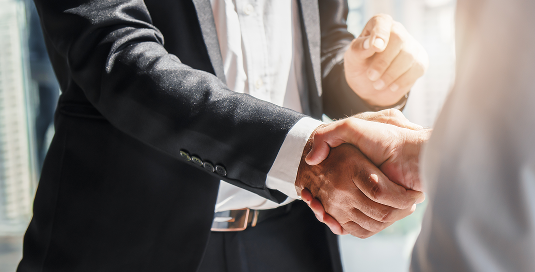 Image of two people in suits shaking hands