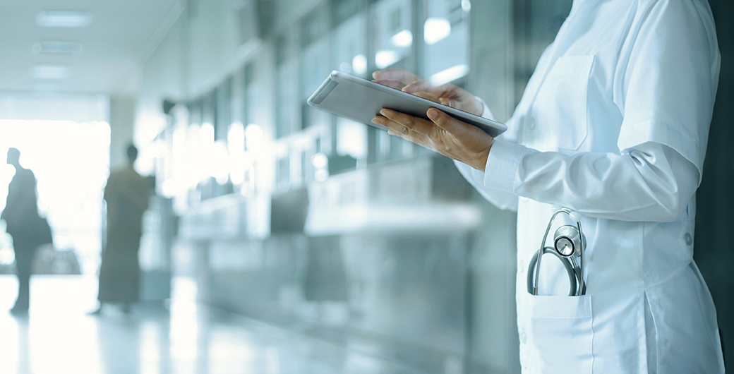 Doctor working on digital tablet on hospital background