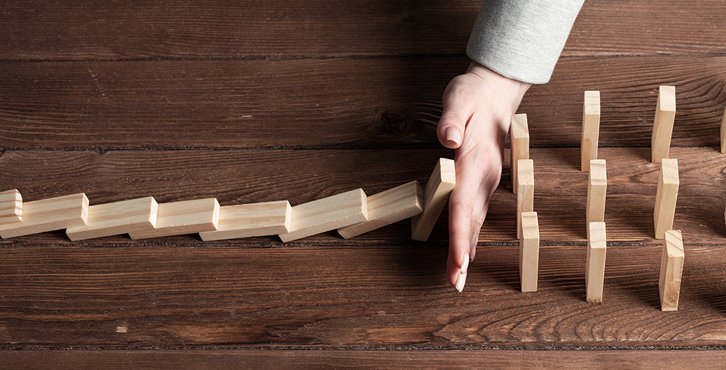 Person protecting dominoes from falling