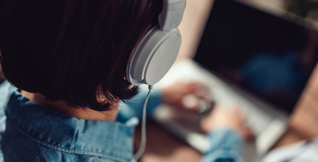 Woman using laptop and listening music on a headphones