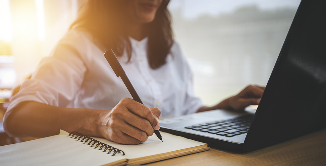 a person taking notes during an online learning session