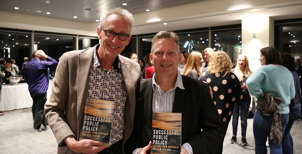 Image of two men smiling at a book launch